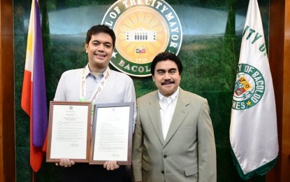 <p><strong>SPECIAL DAY</strong>. Mark John Simondo (left), topnotcher of the 2017 Philippine Bar Examinations, with Bacolod City Mayor Evelio Leonardia who presented him two executive orders recognizing his rare feat in rites held at the Bacolod Government Center on Wednesday (May 2, 2018). <em>(Photo courtesy of Bacolod City PIO)</em></p>